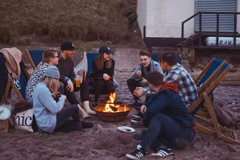 A group of friends around a campfire in the perfect camp spot.
