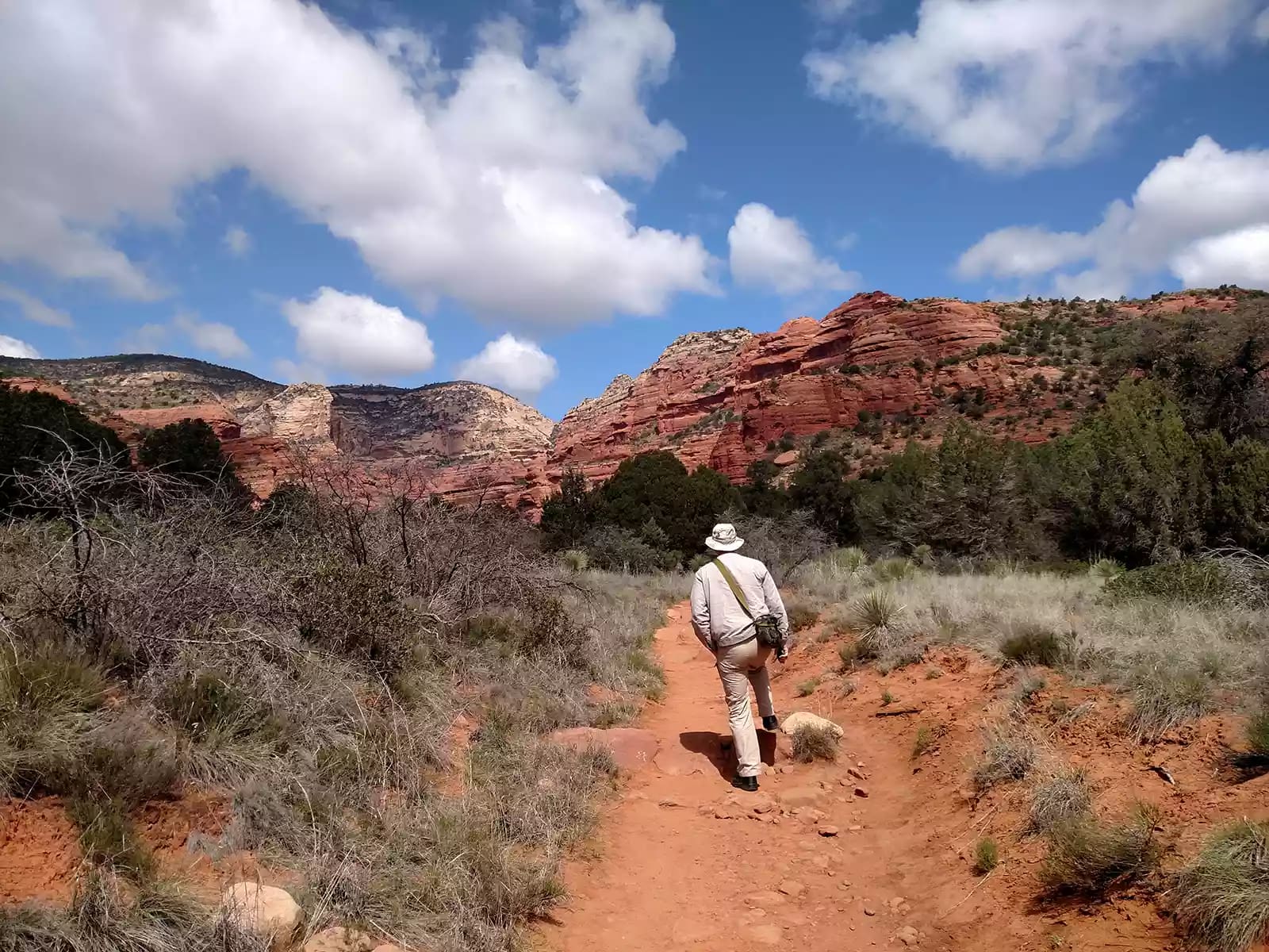 man in khaki hiking through Red Rock Canyon