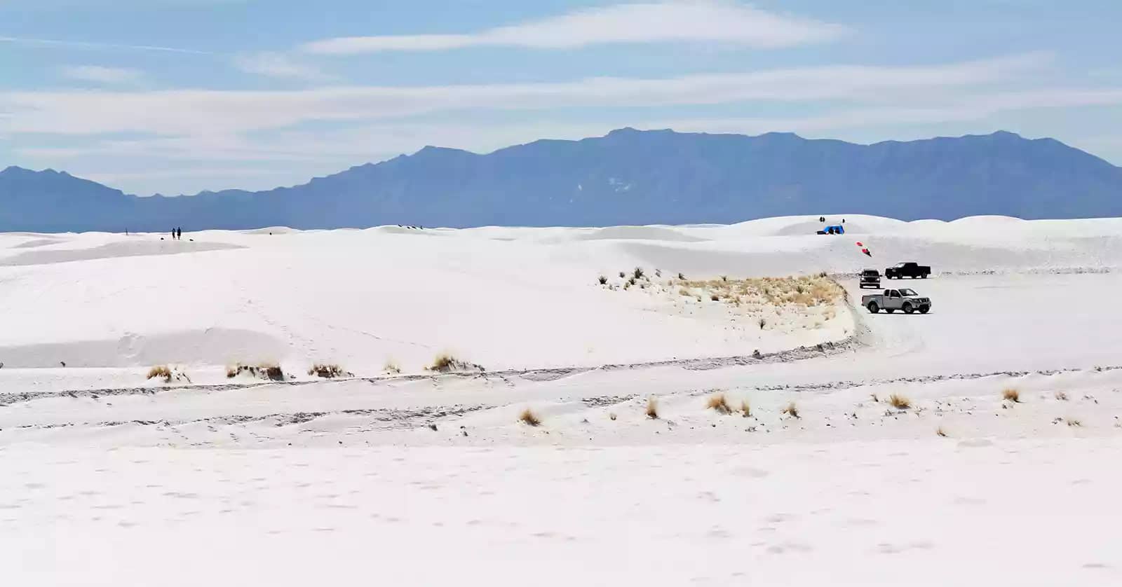 A panorama of snow at White Sands with a mountain backdrop, scenery that's one of the top reasons to go camping in New Mexico