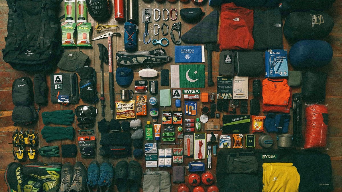 A large amount of camping supplies for camping tips and camping essentials laid out on a table. Photo by Muhammad Masood.
