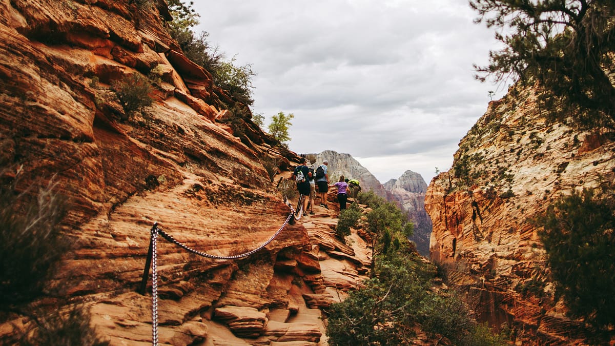 Group of hikers doing Angels Landing in Zion National Park on a cloudy day, beautiful scenery, photo by Alex Holt.