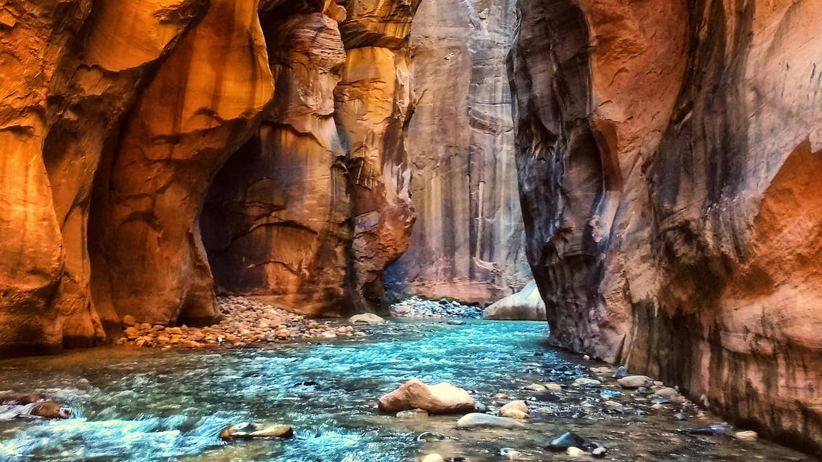Beautiful, colorful, high-definition photo of the narrows and rock formations in Zion National Park with flowing water below, by Karan Chawla.