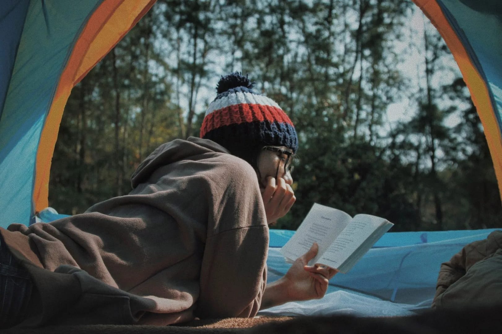 Woman-in-a-tent-reading-while-camping