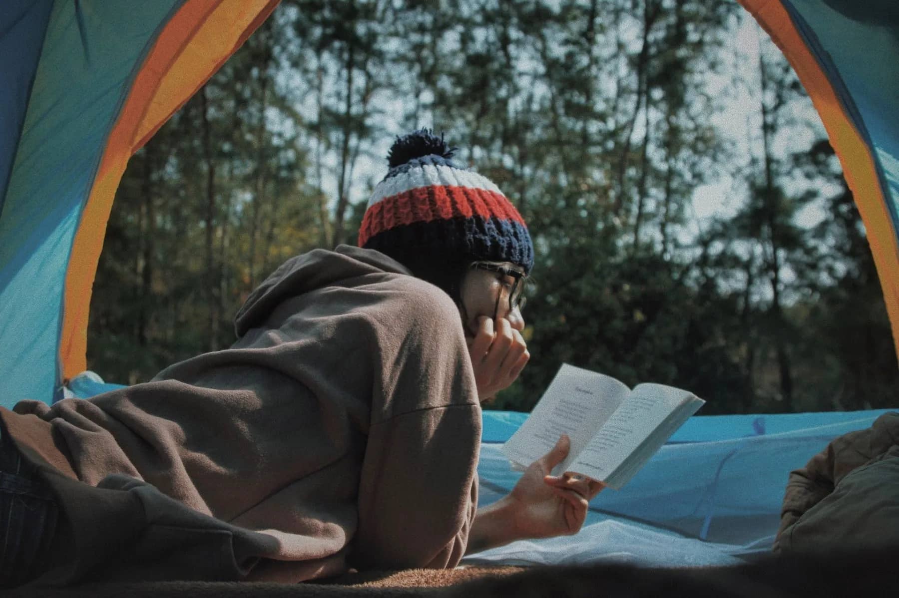 Woman-in-a-tent-reading-while-camping