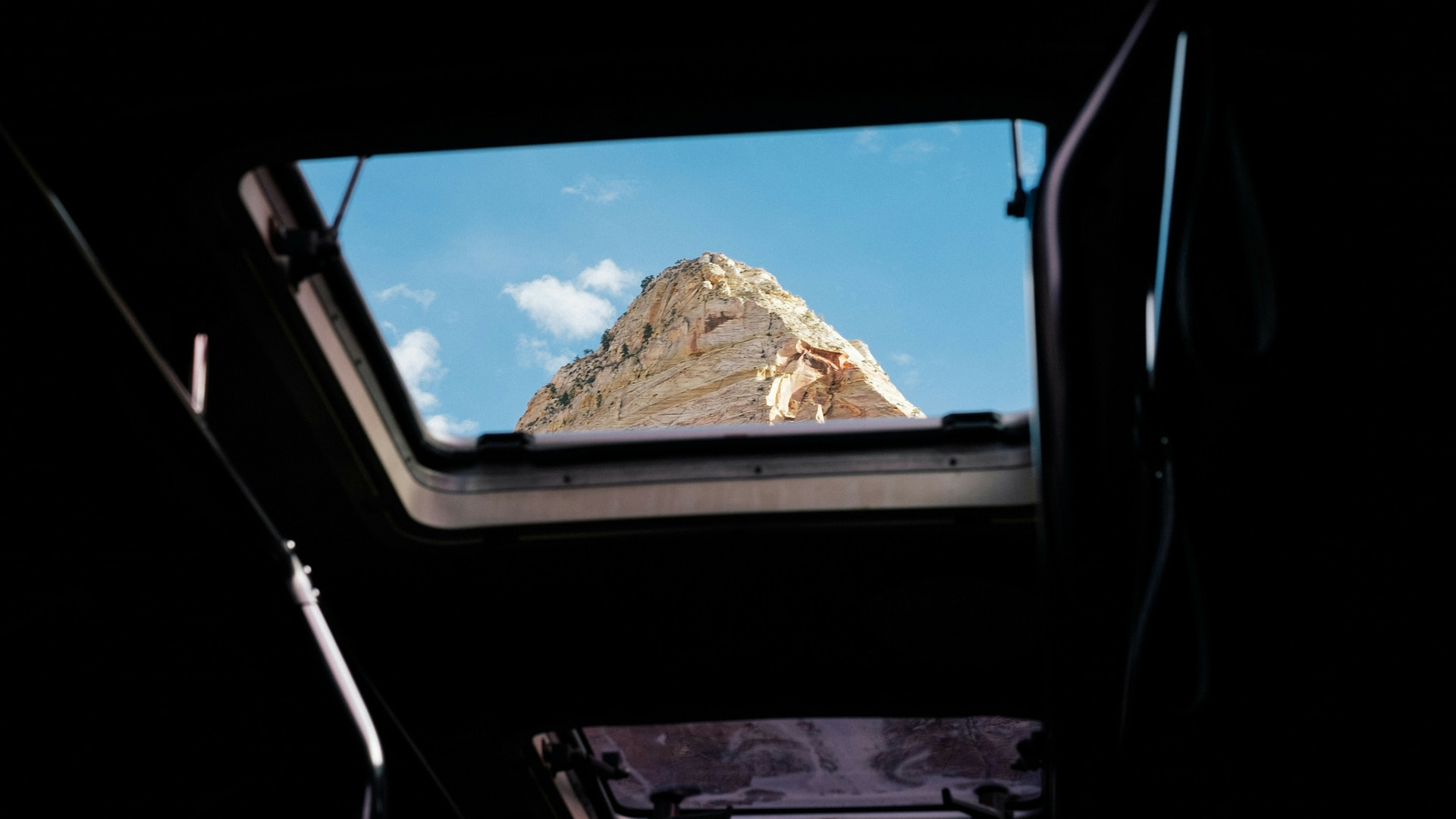 Photo looking up through ceiling windows in an RV at a rock formation in Zion National Park. Photo by PJ Gal.