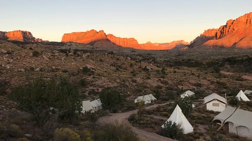 A glamping area overlooking the rock formations and mountains of Zion National Park around sunset. Photo by Bulent Keles.