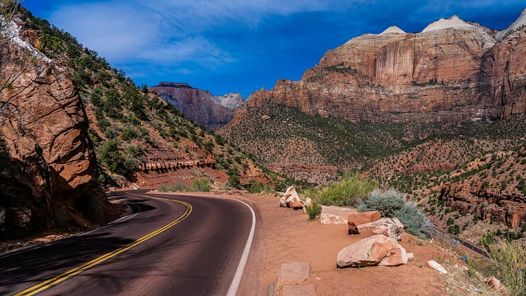 A public access road meandering through a scenic park of Zion National Park on a clear day. Image by Eelco Bohtling.