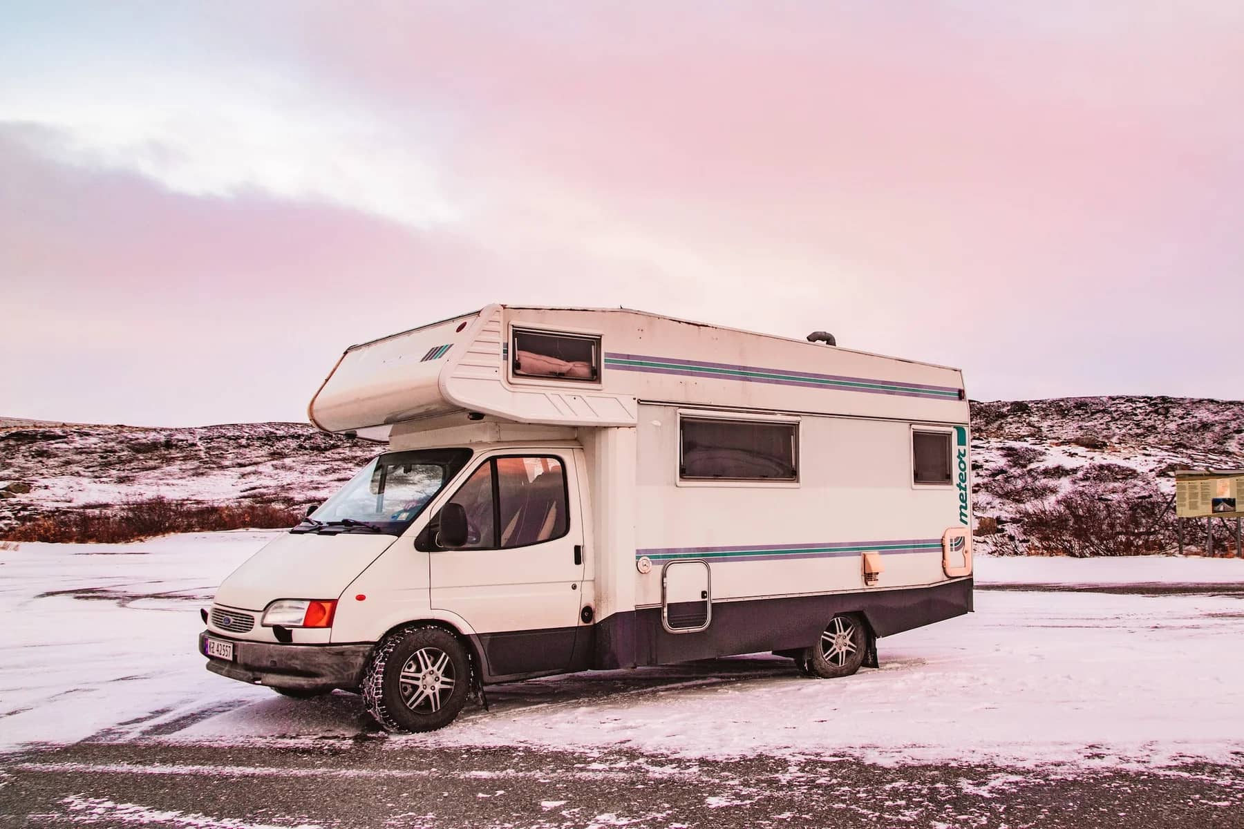Image of a parked RV in snow to convey storing your RV trees