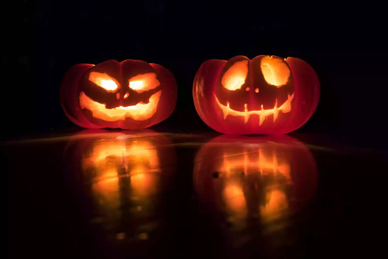 three jack-o-lanterns with candles in the dark