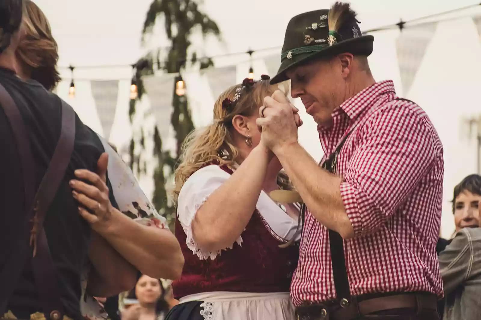 man and woman dancing in German dress during Oktoberfest