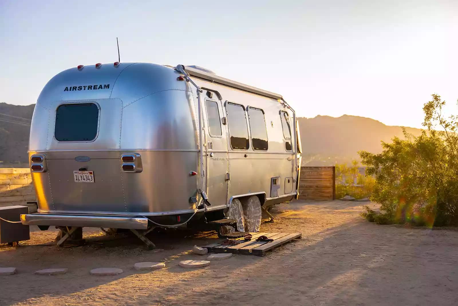 silver airstream camper parked with mountain view