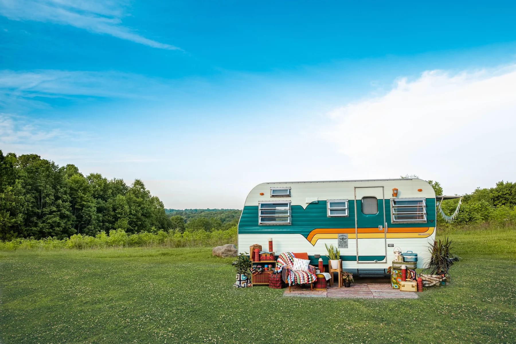 Image of an RV set up in the grass to convey whether you should stay in an RV or a hotel